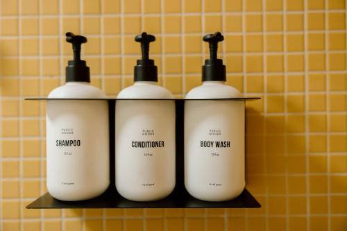 a group of four bottles on a shelf in a bathroom at Mojave Resort - Adults Only in Palm Desert