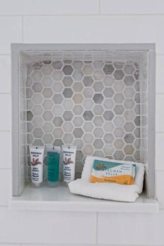 a shelf with three bottles of toothpaste and towels at Ocean Pointe 2309 in Tavernier
