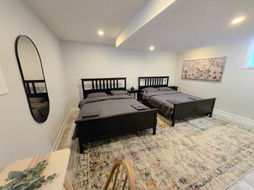 a bedroom with two beds and a mirror at Byward-Market Luxury GuestHouse in Ottawa