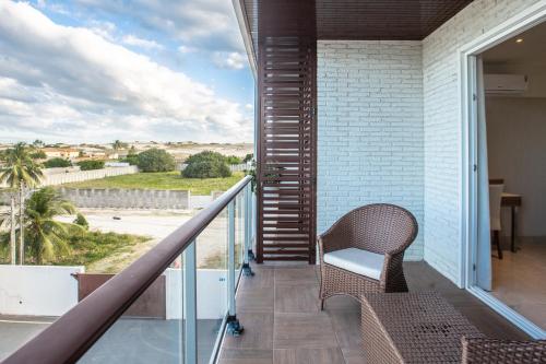 a balcony with a chair and a view of the desert at Hotel Tango Suítes Cumbuco in Cumbuco