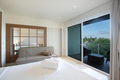 a bedroom with a bed and a large glass window at Hotel Tango Suítes Cumbuco in Cumbuco