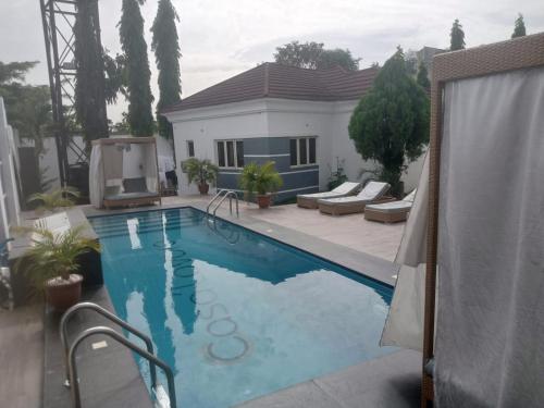 a swimming pool in front of a house at Nene Apartment in Abuja