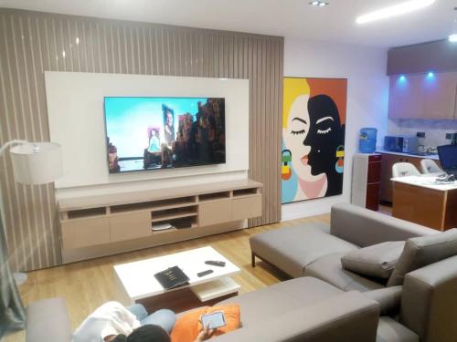 a living room with a couch and a flat screen tv at Nene Apartment in Abuja