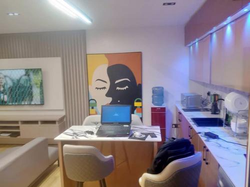 a kitchen with a table with a laptop on it at Nene Apartment in Abuja