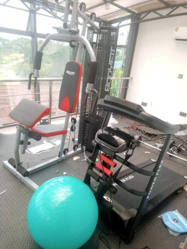 a gym with a treadmill and a chair and a ball at Nene Apartment in Abuja