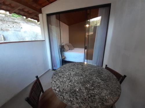 a room with a table and a room with a bed at Suíte independente próxima ao centro histórico de Petrópolis in Petrópolis