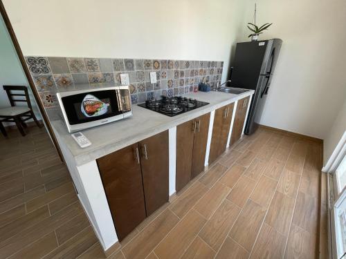 a kitchen with a counter with a stove and a refrigerator at advengers Bucerias Nayarti in Bucerías