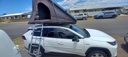 a white car with a tent on top of it at CampCar Maui Jeeps SUVs Hybrid Camper van Rentals with equipment and Travel Advice in Kahului