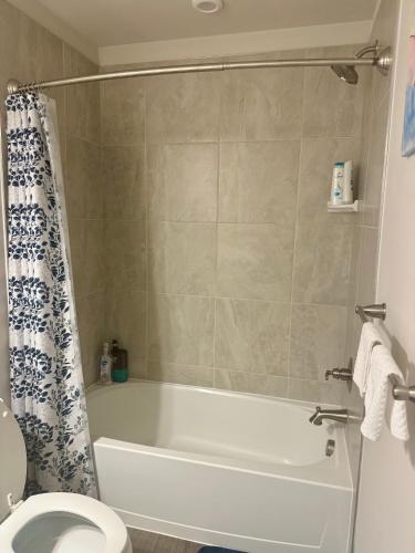 a bathroom with a white tub and a toilet at Home Away in Hanover