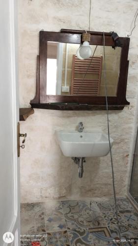 un baño con lavabo y espejo en I trulli di Mani', en Masseria Orimini