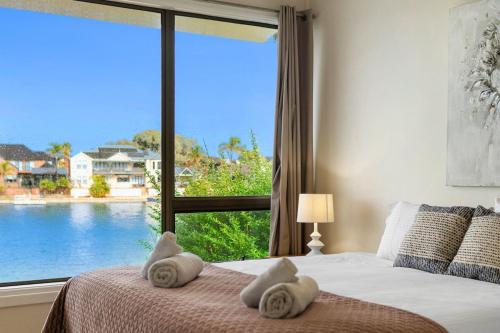 Dormitorio con ventana grande con vistas al agua en Stunning Lake View Townhouse-Dream Staycation, en Cheltenham