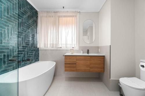 Un baño con bañera, inodoro y lavabo. en Stunning Lake View Townhouse-Dream Staycation, en Cheltenham