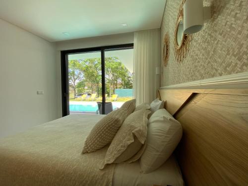 a bedroom with a bed with pillows and a window at Casa tapada da cheda 1 in Fafe