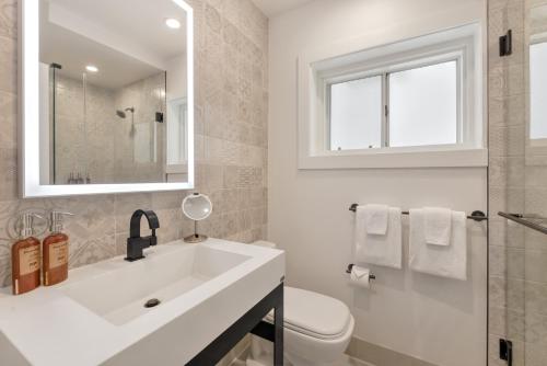 a white bathroom with a sink and a toilet at Laguna Surf Lodge by SCP Hotels in Laguna Beach
