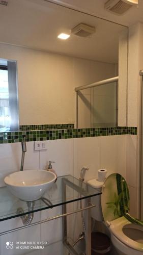 a bathroom with a sink and a toilet and a mirror at Apartment Neo 2.0 in Maceió