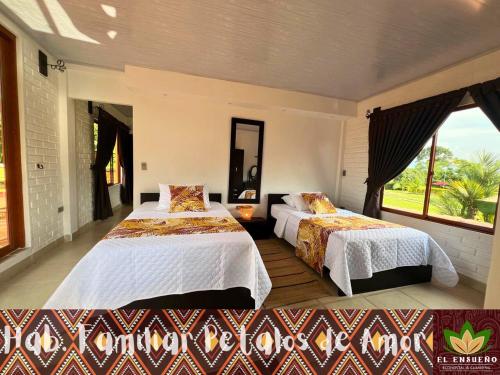 a bedroom with two beds and a large window at El Ensueño Ecohostal & Glamping in Mocoa