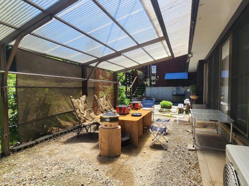 a greenhouse with a table and chairs in it at 民泊ウトカ in Ena