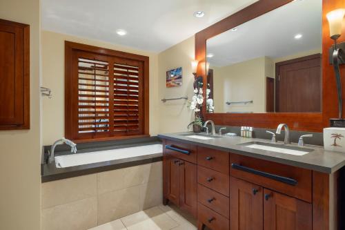 a bathroom with two sinks and a large mirror at Ko Olina Beach Villas O1406 in Kapolei