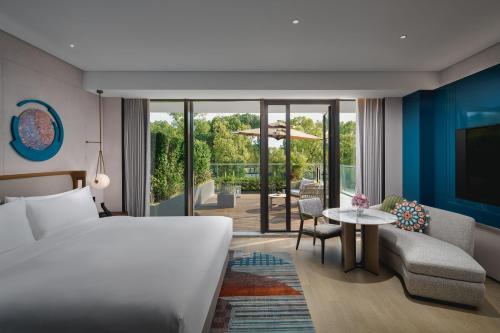 a hotel room with a bed and a patio at Hotel Indigo Suzhou Jinji Lake, an IHG Hotel in Suzhou