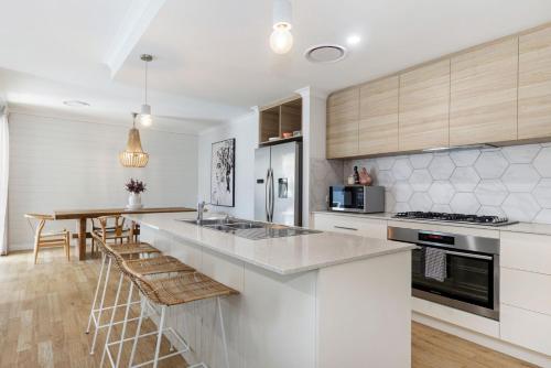 a kitchen with white cabinets and a counter top at Busselton Beachside Beauty in Busselton