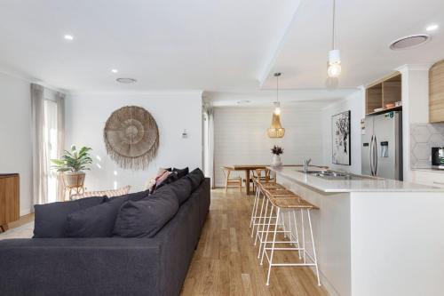 a living room with a couch and a kitchen at Busselton Beachside Beauty in Busselton