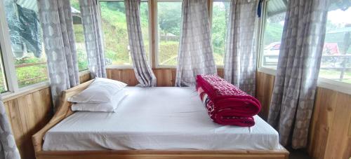 a bed in a room with a large window at Zero Points TheLaure Cottage in Ilām