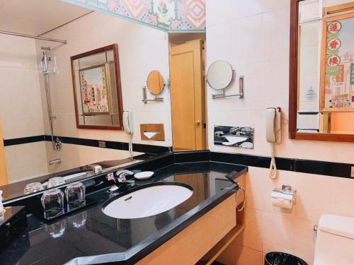 a bathroom with a sink and a mirror at Baiyun Hotel Guangzhou in Guangzhou