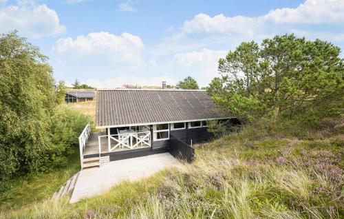 a house on a hill with a wooden walkway at Tziki in Fanø