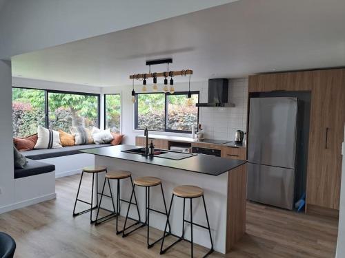 a kitchen and living room with a counter and stools at Peaceful and Secluded, yet so close to town! in Wanaka