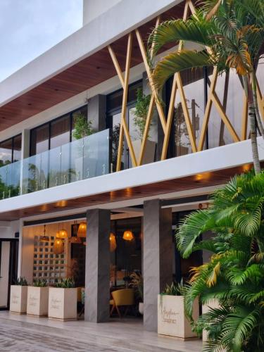 a building with palm trees in front of it at Hotel Tepeu in Santa Elena