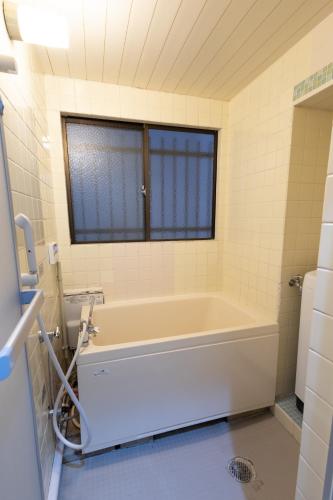 a bath tub in a bathroom with a window at LN07 三宮中心14名まで宿泊可能! 交通至便! Sannomiya Base 2 in Kobe