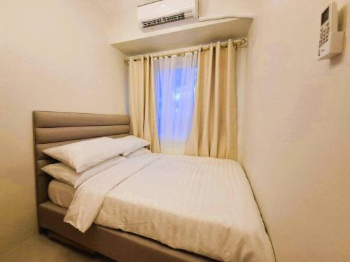 a bed in a small room with a window at Comfy Condo Near NAIA Airport in Manila