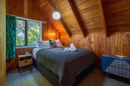 a bedroom with a bed in a wooden room at Tranquil Retreat in Taupo