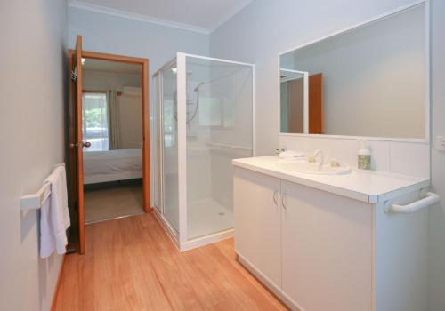 Un baño blanco con ducha y lavabo. en Bright Country Home, en Bright