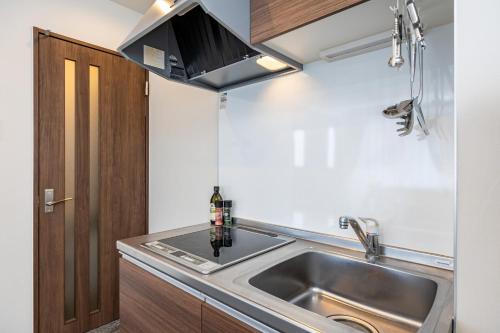 a small kitchen with a sink and a microwave at AI Annex in Osaka