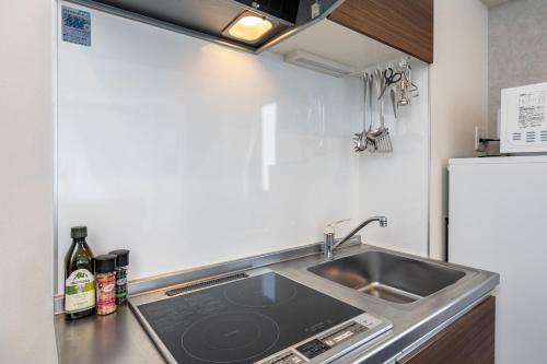 a kitchen with a sink and a refrigerator at AI Annex in Osaka