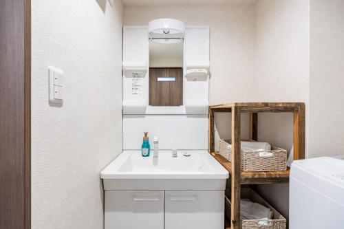a bathroom with a white sink and a mirror at AI Annex in Osaka