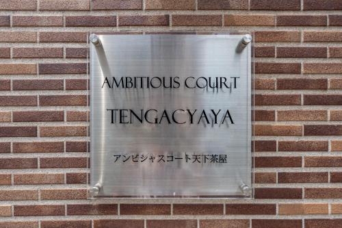 a sign on the side of a brick wall at AI Annex in Osaka