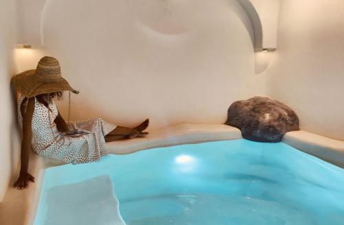 a woman sitting on a bed in a swimming pool at Kaleydo Villas in Gili Trawangan