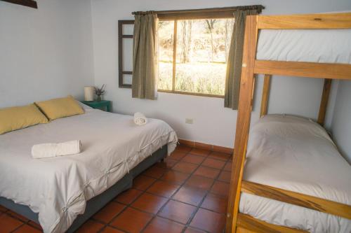 a bedroom with two bunk beds and a window at Loma Puskana - Hostería in Cachí