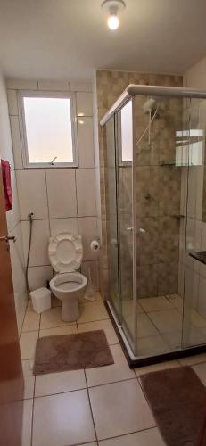 a bathroom with a toilet and a glass shower at Apartamento Aconchegante! in Uberaba