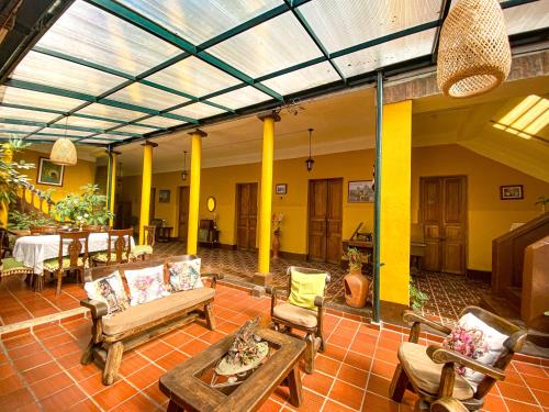 a living room with chairs and a table and a couch at Hotel Villa Mercedes Colonial in Sopó