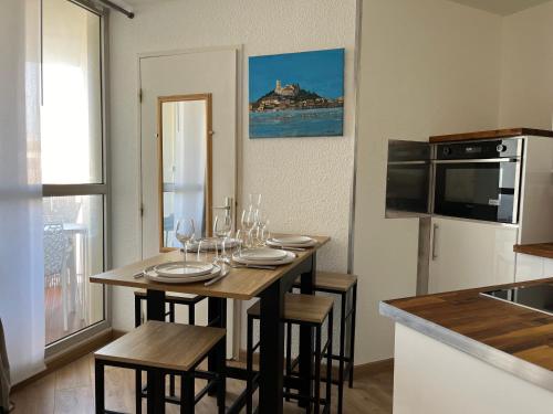 une cuisine avec une table avec des verres à vin dessus dans l'établissement Studio cabine cosy avec parking à Gruissan, 4 pers., proche port et commerces - FR-1-796-80, à Gruissan