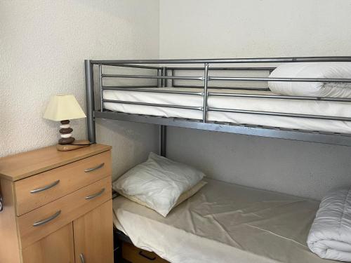 une chambre avec deux lits superposés avec une lampe et une commode dans l'établissement Studio cabine cosy avec parking à Gruissan, 4 pers., proche port et commerces - FR-1-796-80, à Gruissan