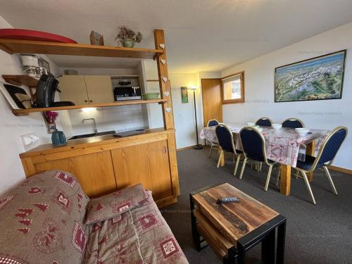 une pièce avec une table et des chaises et une cuisine dans l'établissement Vallandry : Duplex 3 pièces, 8 pers, accès direct pistes, animaux admis, casier à skis - FR-1-757-102, à Landry