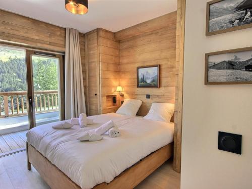 une chambre avec un grand lit avec une grande fenêtre dans l'établissement Très beau 4 pièces à Méribel Mottaret - neuf, parking couvert, accès rapide aux pistes - FR-1-411-944, à Les Allues