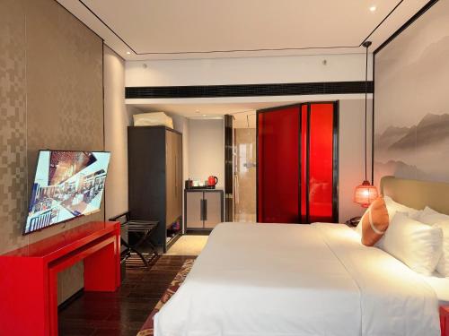 a bedroom with a large bed and a flat screen tv at Baiyun Hotel Guangzhou in Guangzhou