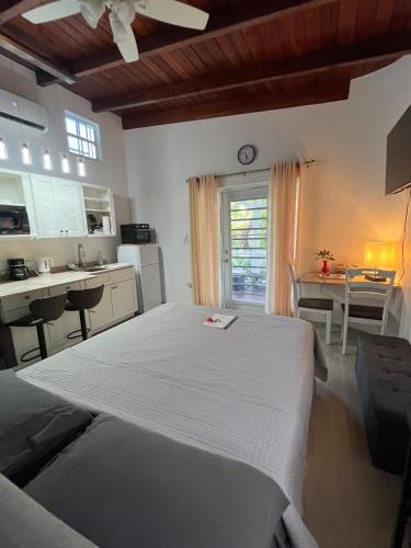a bedroom with a large bed and a kitchen at LaBelleVue Antigua Oceanview Suites and OnSite Car Rentals in Crosbies