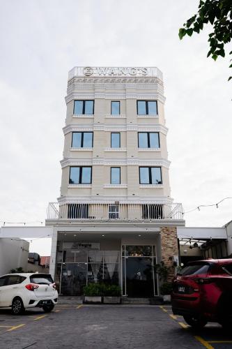 a white car parked in front of a building at Wangs Hotel Gurney Drive in George Town