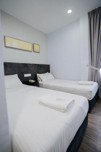 a row of three beds in a hotel room at Wangs Hotel Gurney Drive in George Town
